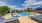 Large sparkling blue pool with a large pool deck and lounge chairs