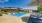 Large sparkling blue pool with a large pool deck and lounge chairs